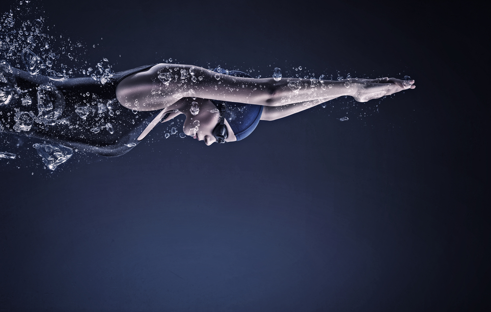 Wedstrijd zwemster met stevige schouderpartij, na duik onderwater.