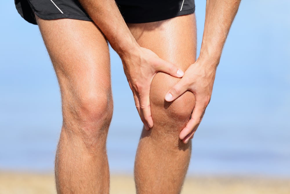 Sporter grijpt naar pijnlijke knie die mogelijk relatie heeft met zijn heup.