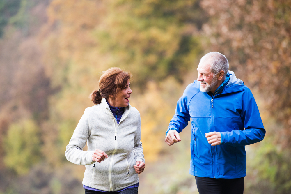 Fitte ouderen gezellig aan het joggen in de natuur.