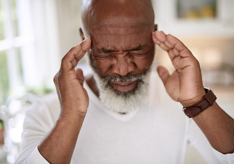 Shot of a mature man suffering from a headache at home