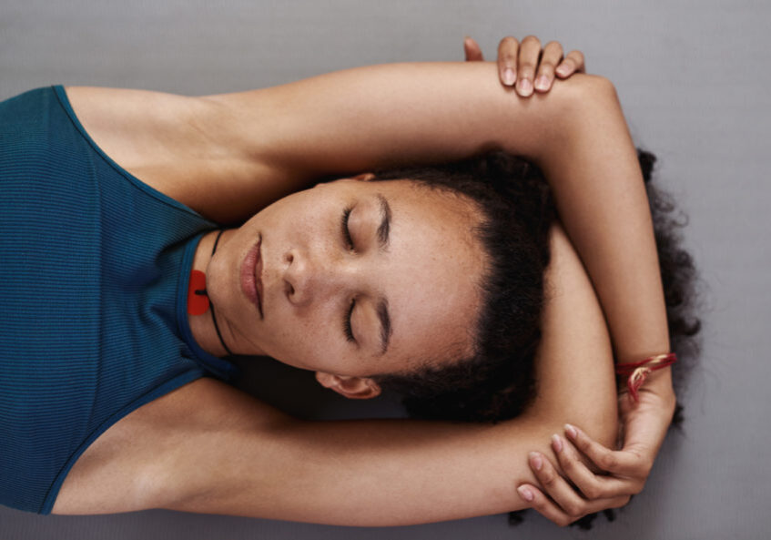 Shot of a young woman resting after her yoga session