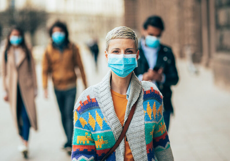 Portrait of young woman on the street wearing face protective mask to prevent Coronavirus and anti-smog