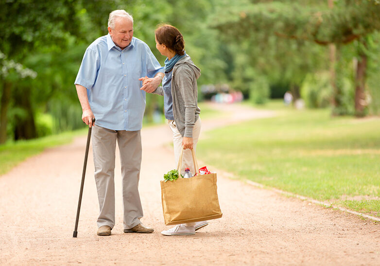 Senior man with caregiver going shopping at market place