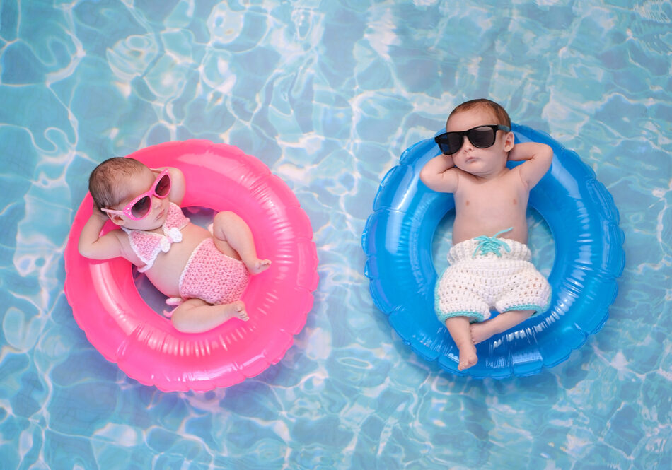 Twee kindjes op zwembandjes in het water alsof ze een duo vormen.